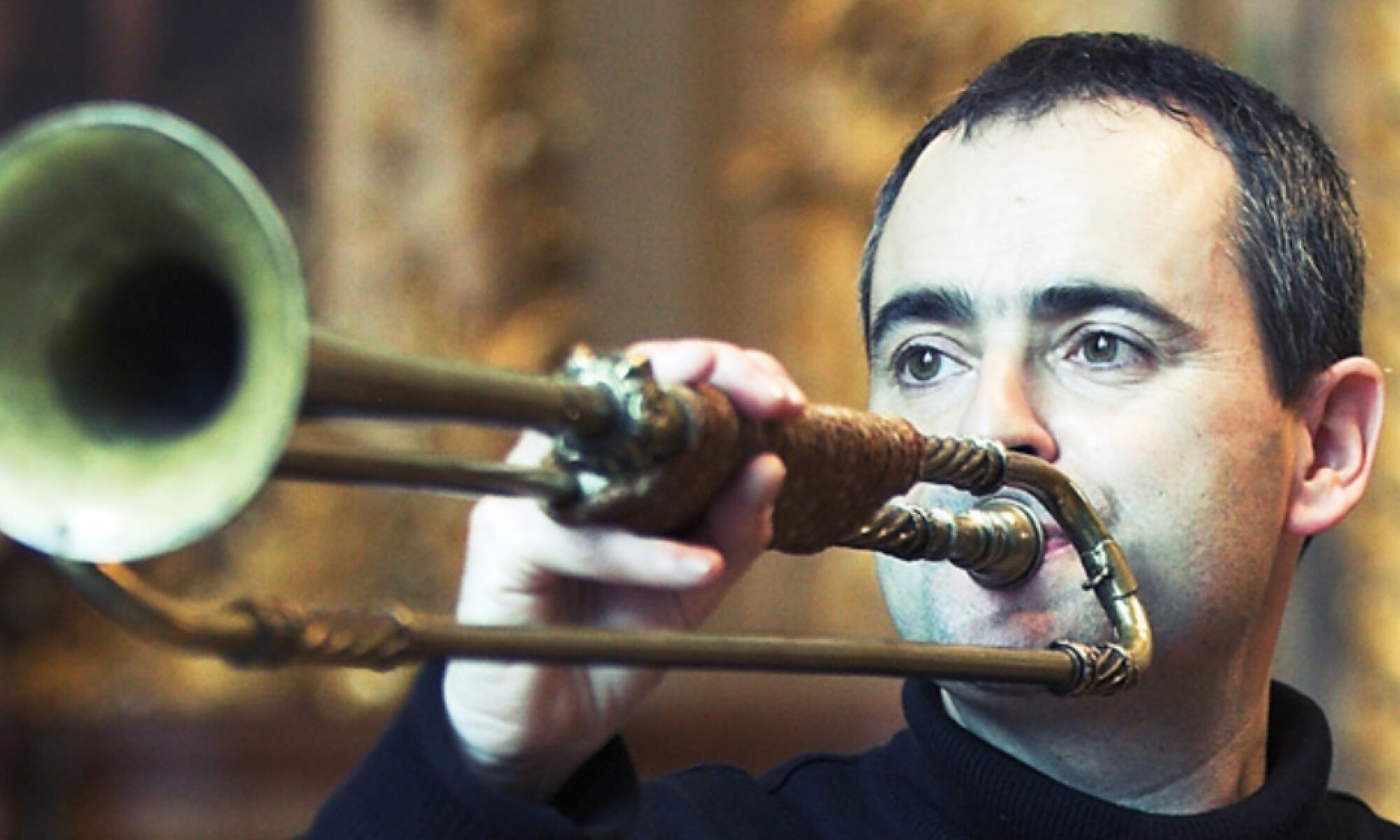 A close-up of Jean-François Madeuf playing a natural trumpet