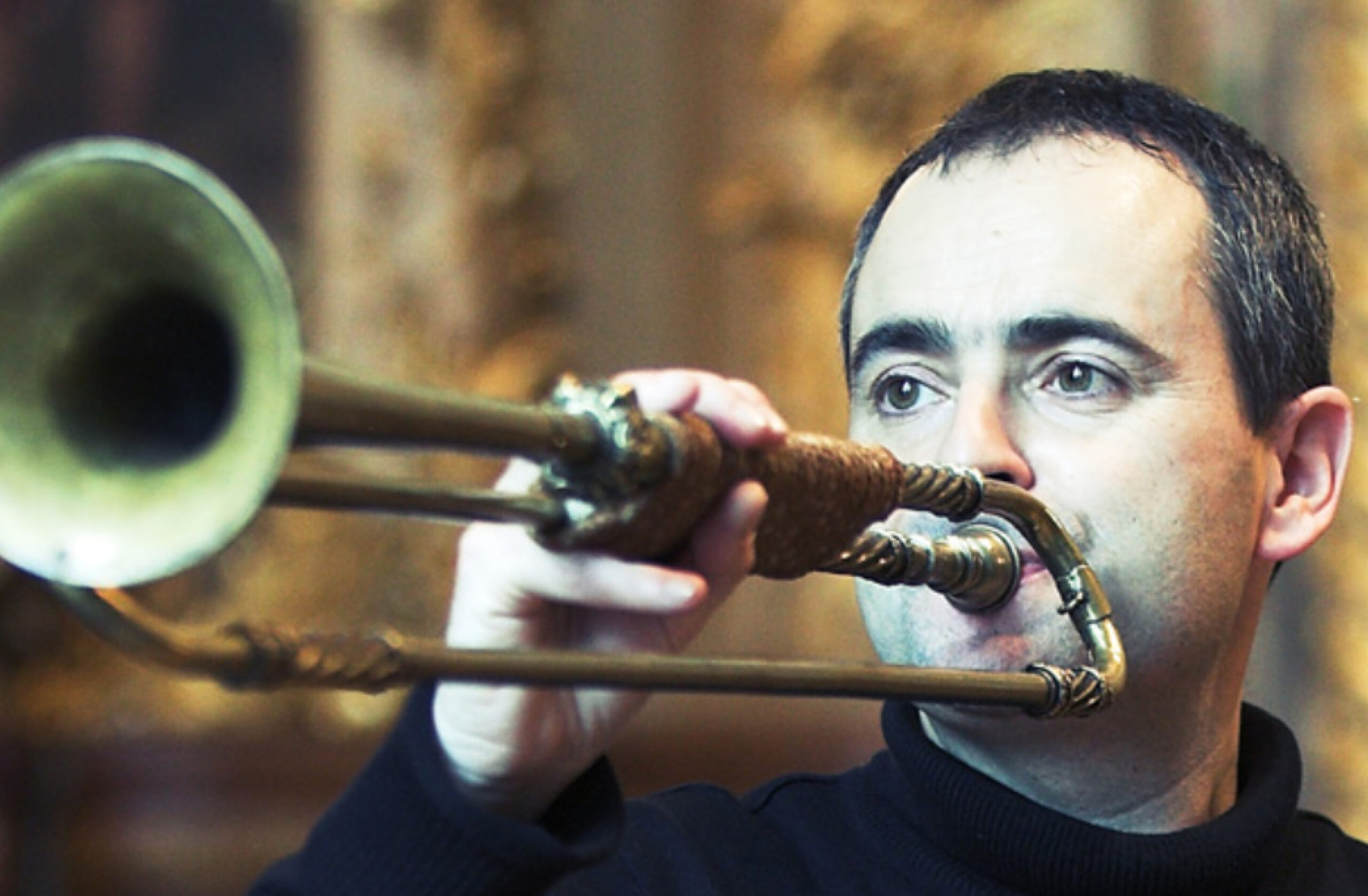A close-up of Jean-François Madeuf playing a natural trumpet
